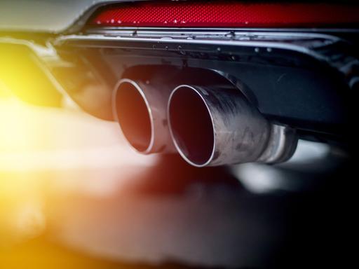 Nahaufnahme eines Auspuffrohrs eines Autos im Sonnenlicht