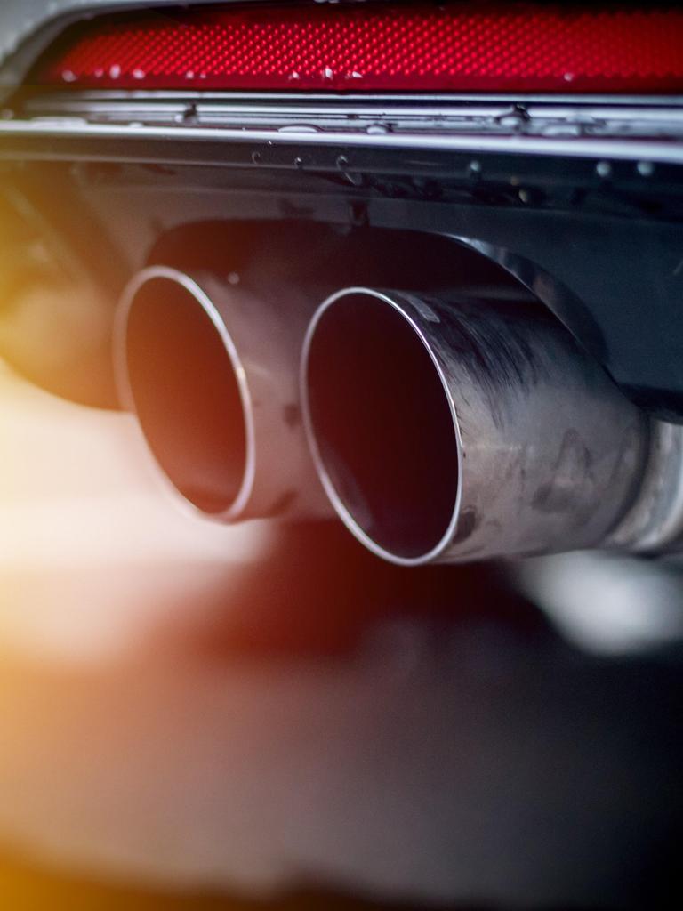 Nahaufnahme eines Auspuffrohrs eines Autos im Sonnenlicht