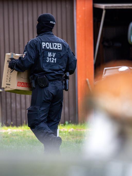 Polizisten sichern Beweismittel in dem Haus eines bundesweit bekannten Rechtsextremisten