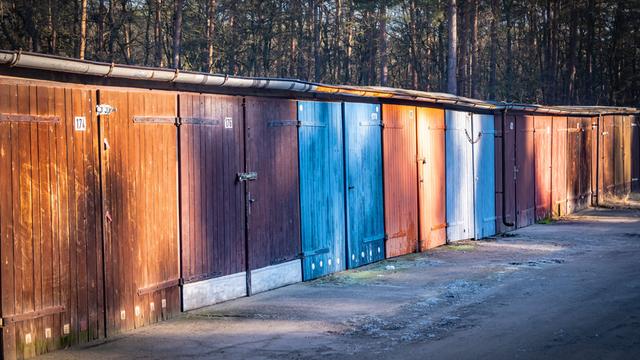 Ein Bild von Gararen aus DDR-Zeiten in Hennigsdorf im Bundesland Brandenburg. Sie scheinen aus Holz gefertigt zu sein. Die Tore sind bunt gestrichen, aber der Lack löst sich.