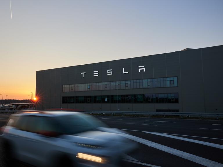 Blick auf ein Werk des Autobauers Tesla bei Sonnenuntergang am frühen Abend.