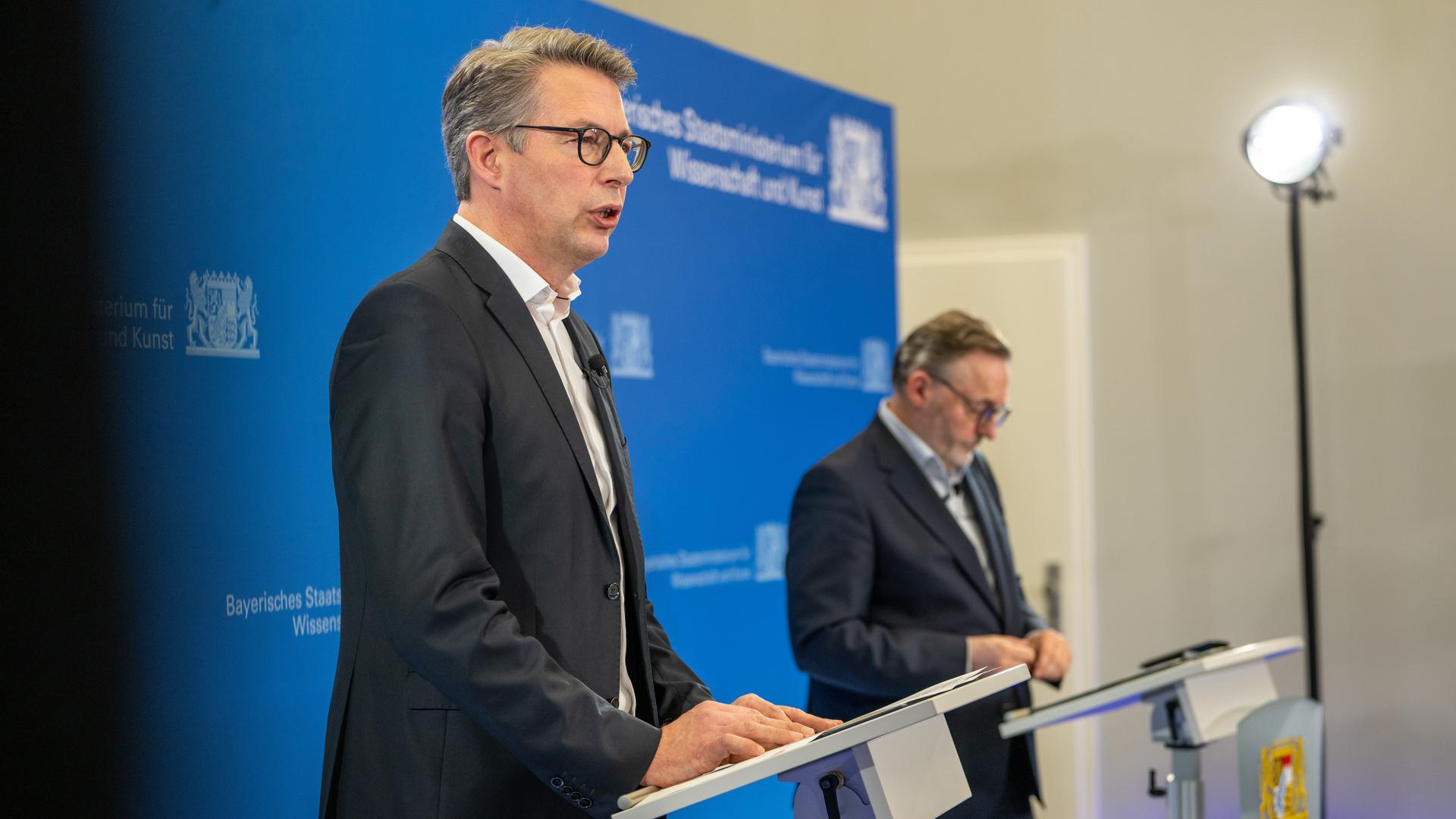 Markus Blume, ein Mann mittleren Alters in dunklem Anzug, spricht bei einer Pressekonferenz ins Mikrofon. Rechts neben ihm steht Anton Biebl, ebenfalls mittleren Alters, ebenfalls im dunklen Anzug und mit ernstem Gesichtsausdruck. Markus Blume, ein Mann mittleren Alters in dunklem Anzug, spricht bei einer Pressekonferenz ins Mikrofon. Rechts neben ihm steht Anton Biebl, ebenfalls mittleren Alters, ebenfalls im dunklen Anzug und mit ernstem Gesichtsausdruck.