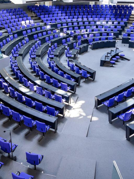 Blaue Stühle im Rund um ein Rednerpult: Plenarsaal des Bundestags in Berlin