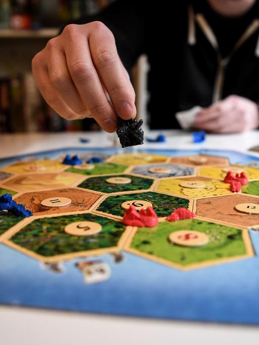 Jemand spielt das Brettspiel "Siedler von Catan". 