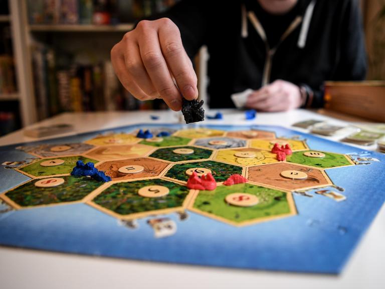 Jemand spielt das Brettspiel "Siedler von Catan". 