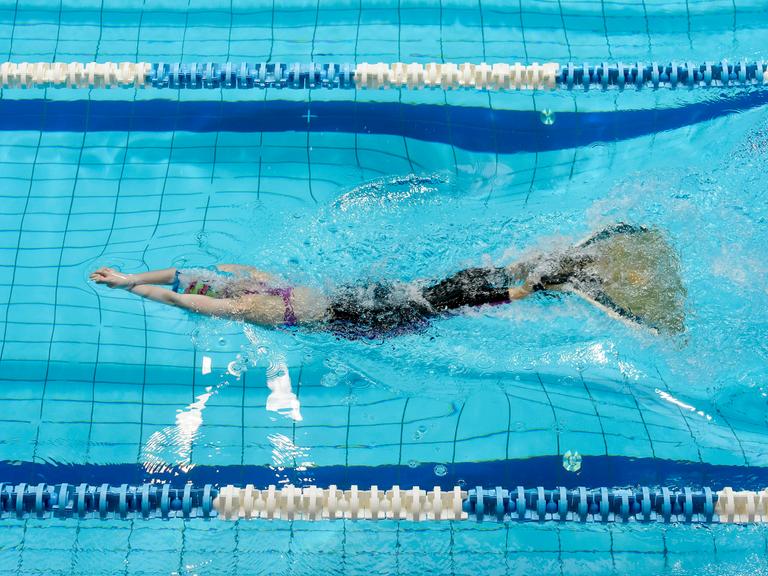 Finswimming Wettbewerb: Eine junge Schwimmerin mit einer Monoflosse im Wasser.