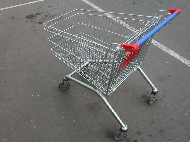Ein leerer Einkaufswagen auf einer Straße.