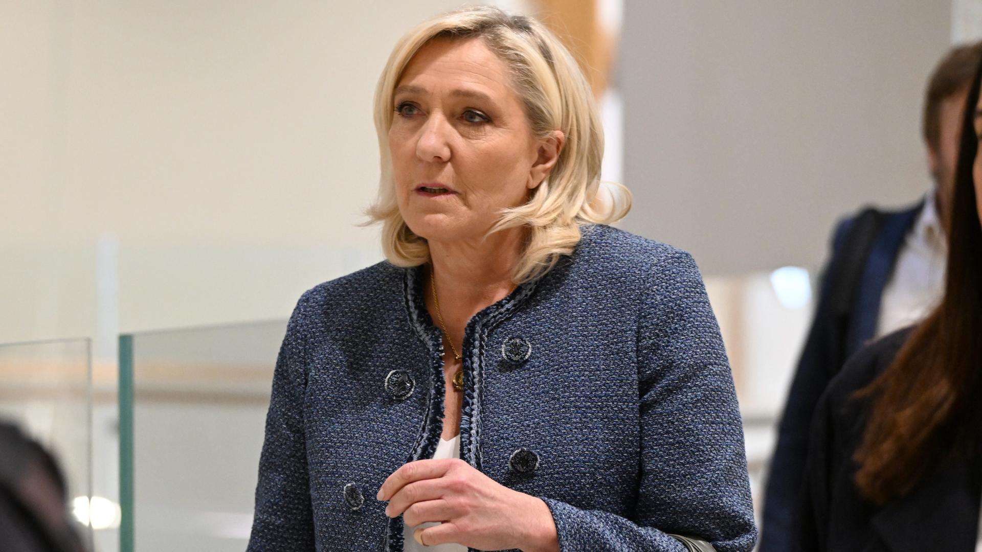 Die Rechtspopulistin Marine Le Pen im Pariser Gericht, wo das Urteil gegen sie verkündet wurde. Sie trägt eine blaue Jacke und schaut ernst. 