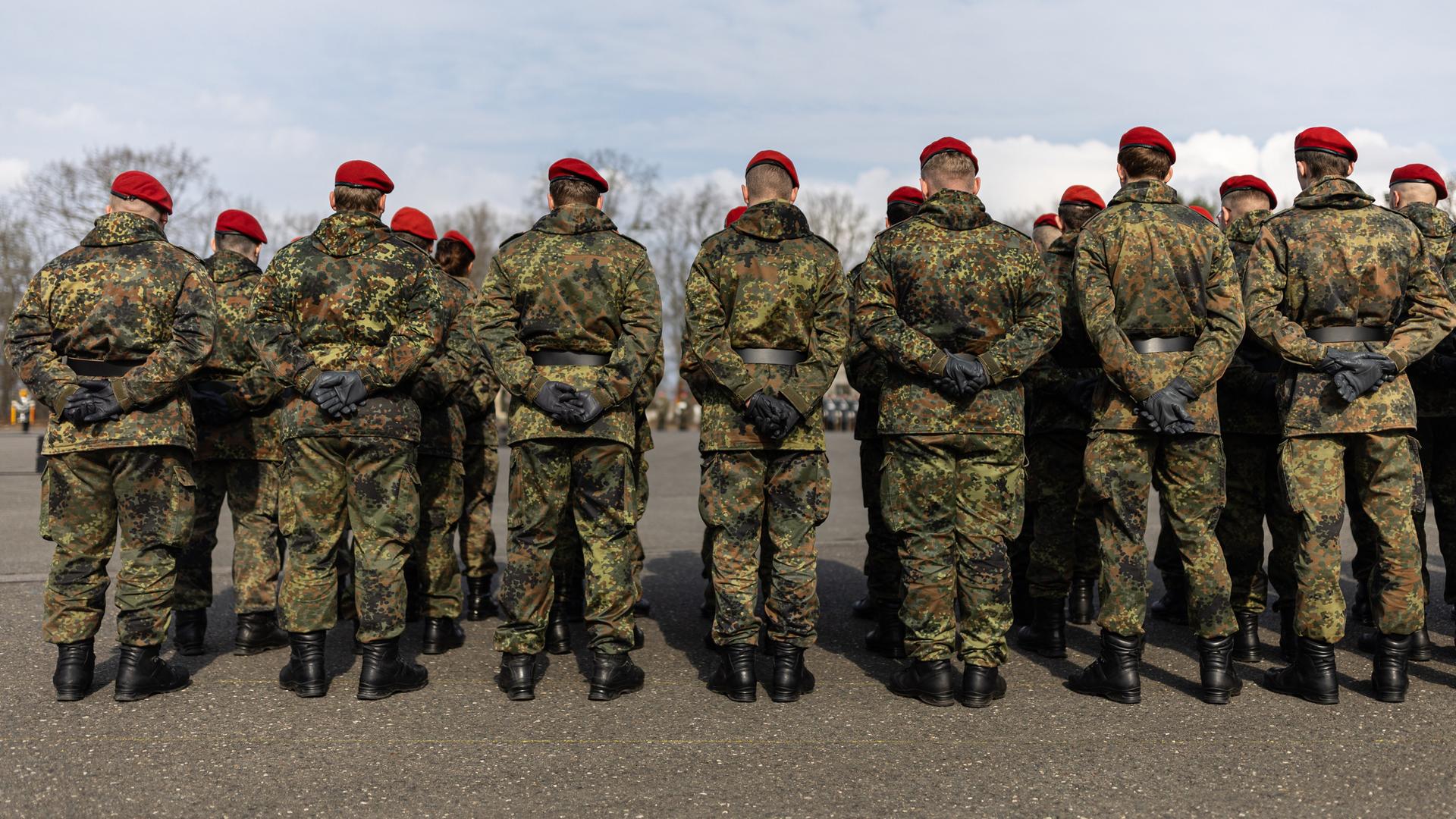 Mehrere Soldaten stehen auf einem Platz in einer Kaserne. Mehrere Soldaten stehen auf einem Platz in einer Kaserne.