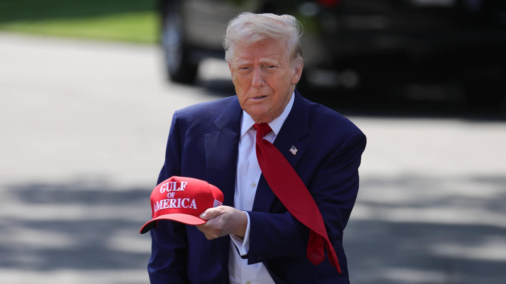 US-Präsident Donald Trump hält eine rote Basecap mit der Aufschrift "Gulf of America" in der Hand